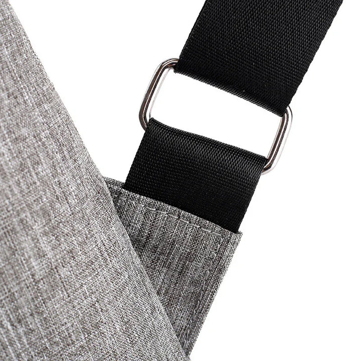 Close-up of grey fabric bag with black adjustable strap and metal buckle detail