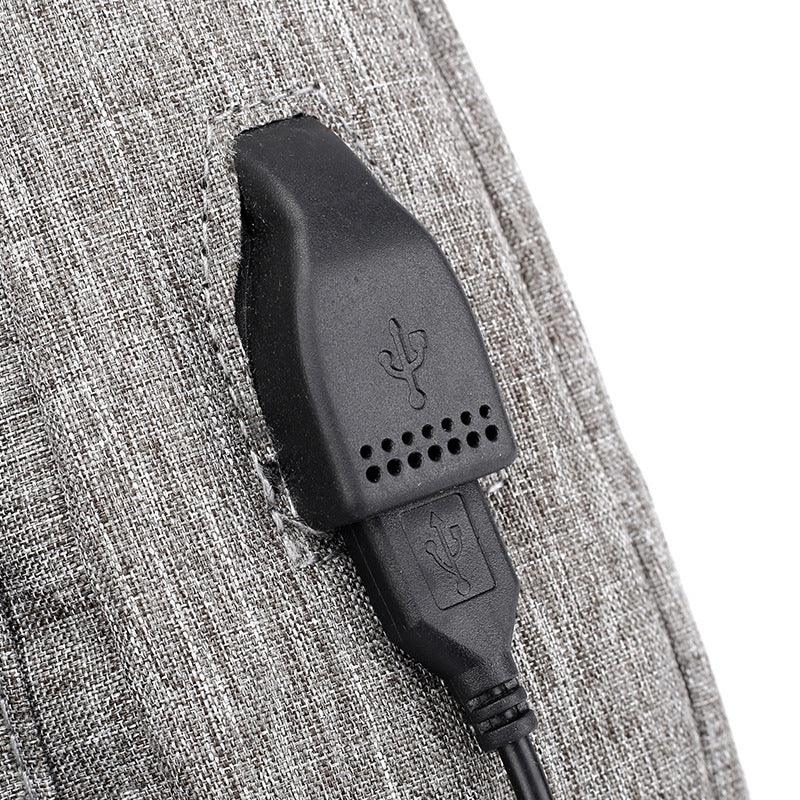 Black USB charging port embedded in gray fabric surface with visible stitching