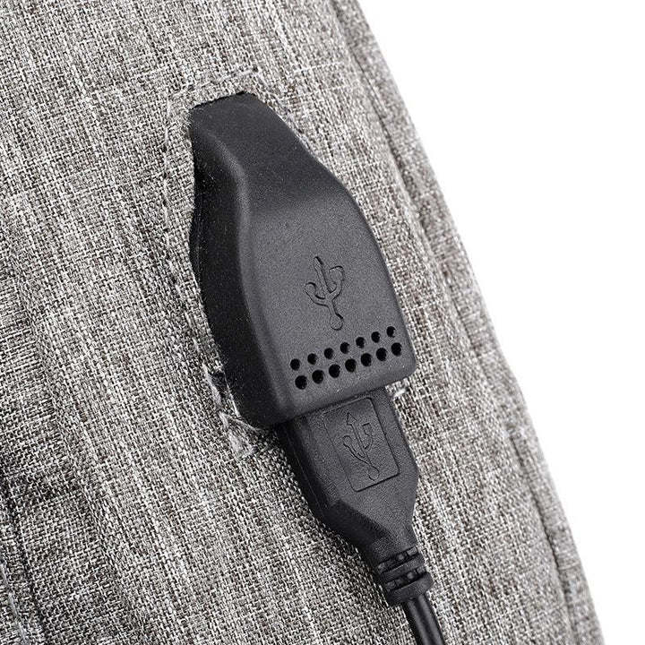 Black USB charging port embedded in gray fabric surface with visible stitching