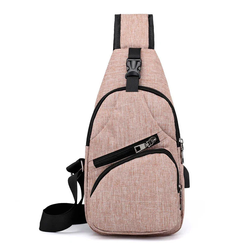 Compact pink crossbody sling bag with black zippers and adjustable strap on white background
