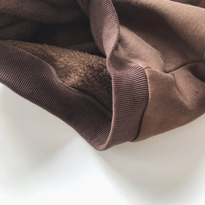 Close-up of brown fleece-lined fabric and ribbed cuff, soft warm clothing detail
