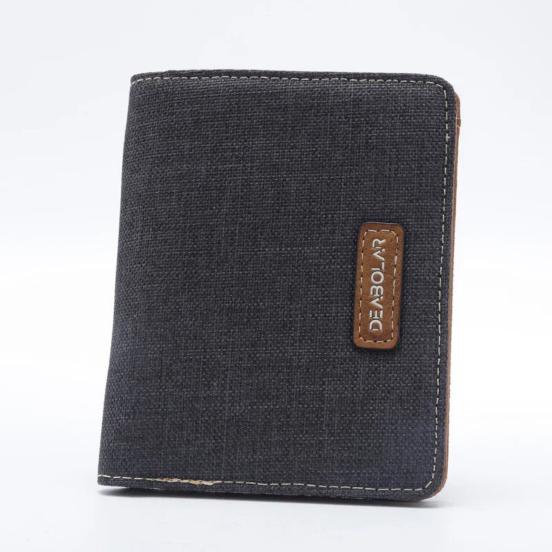 Black canvas wallet with brown leather patch and white stitching on a white background