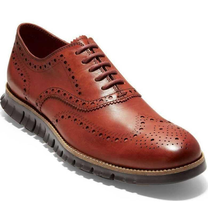 Men's brown leather wingtip brogue shoe with black rubber sole and detailed perforations