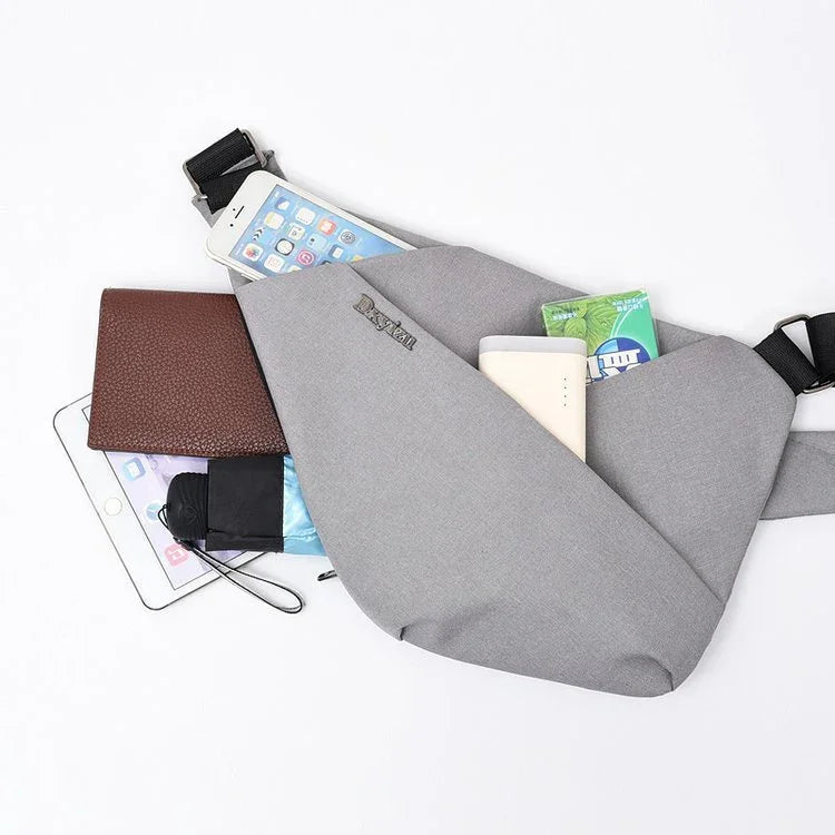 Gray crossbody bag with phone, brown wallet, tissues, power bank, and small umbrella on white background