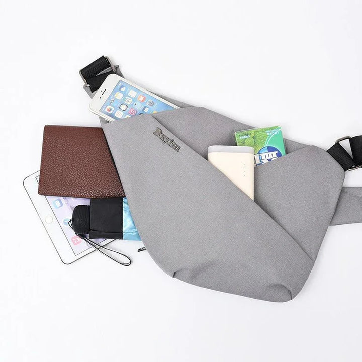 Gray crossbody bag with phone, brown wallet, tissues, power bank, and small umbrella on white background