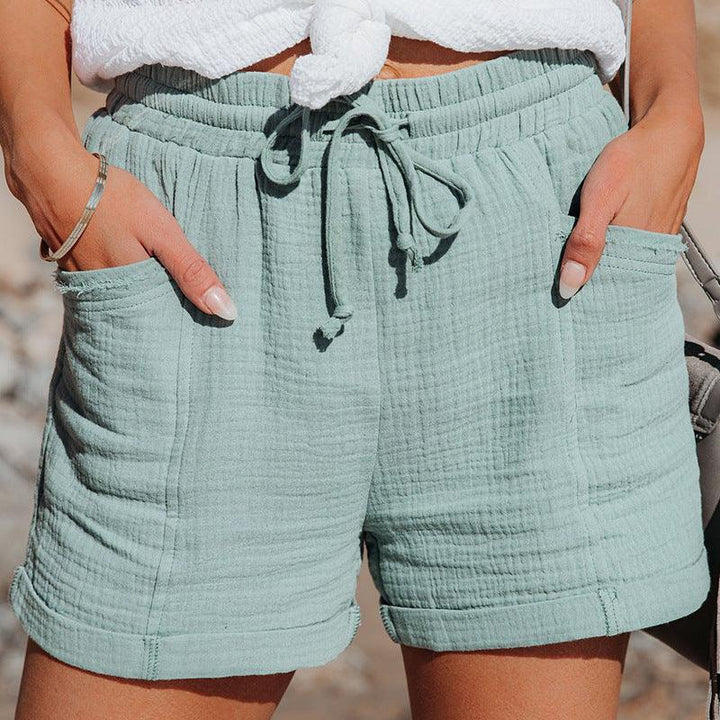 Woman wearing light green textured casual shorts with drawstring and front pockets
