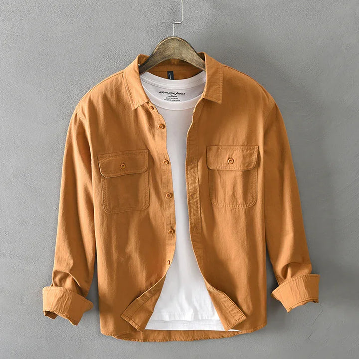 Casual rust orange button-up shirt with chest pockets over white cotton t-shirt on wooden hanger