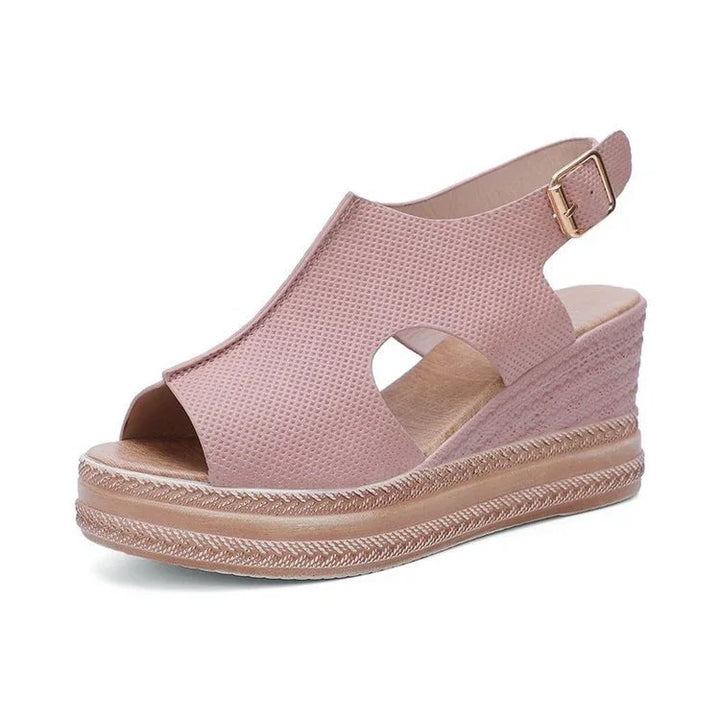 Pink women's open-toe wedge sandals with textured upper and adjustable ankle strap