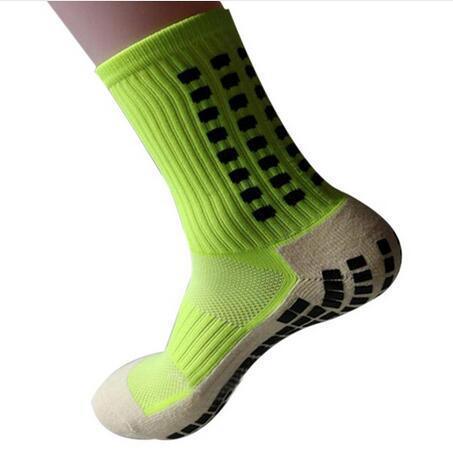 Neon yellow athletic grip sock with black anti-slip pads on sole and sides