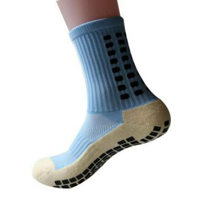 Light blue non-slip grip sock with black rubber dots on sole and sides, isolated on white