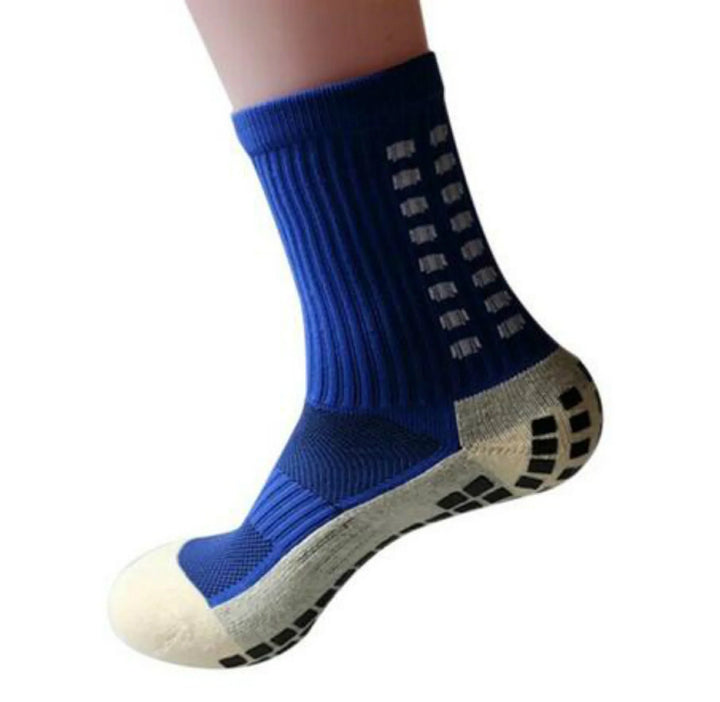 Blue non-slip athletic sock with white grip pads on sole and ankle, isolated on white background