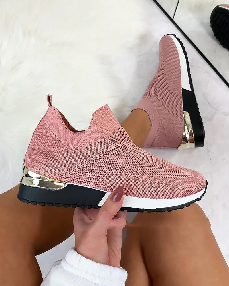 Pink knitted slip-on sneakers with black and white sole and metallic gold heel detail
