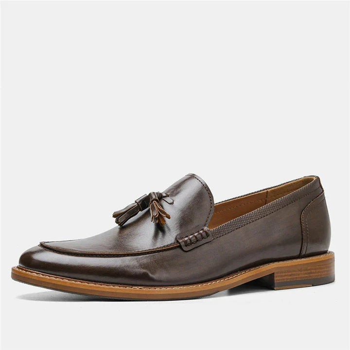 Brown leather men's tassel loafer with stitched detailing and wooden sole on white background