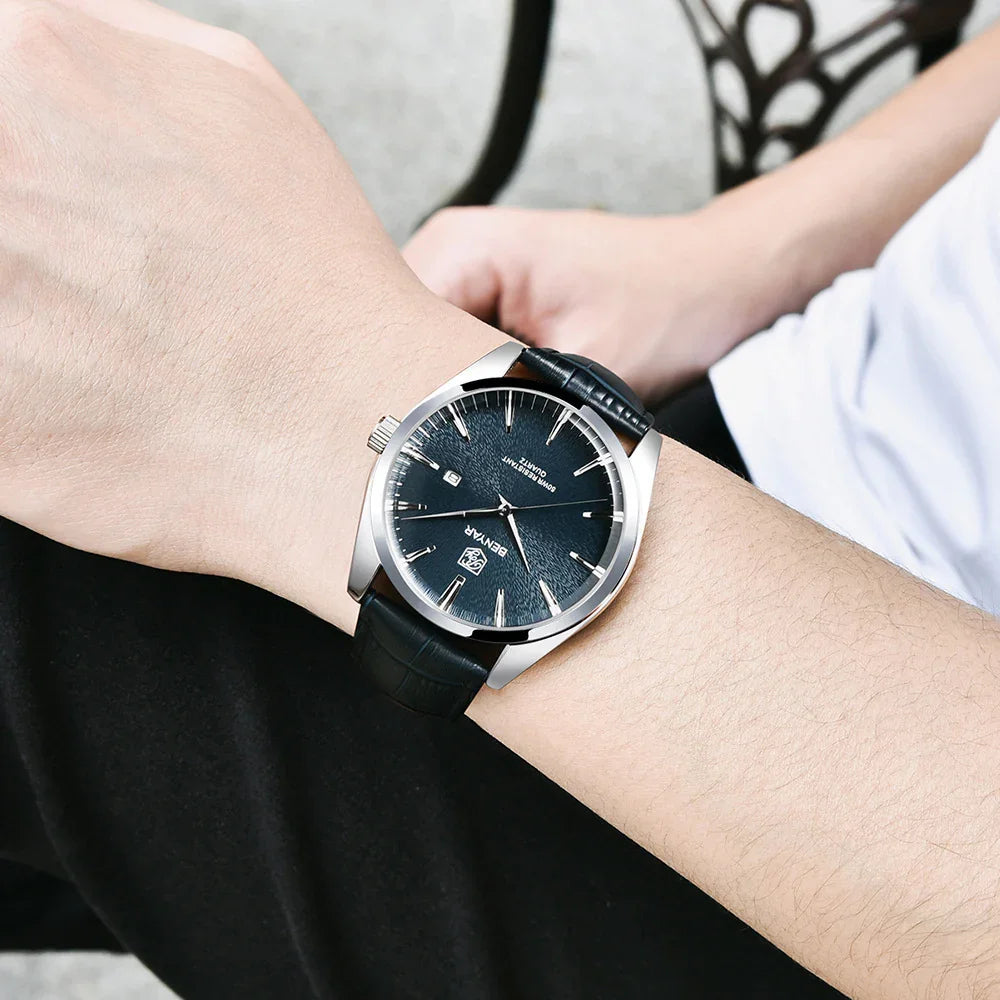 Close-up of wristwatch with black leather strap and blue textured dial on person's wrist