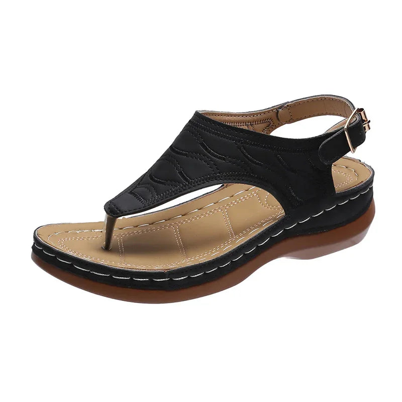 Black leather women's wedge sandal with beige cushioned footbed and adjustable ankle strap