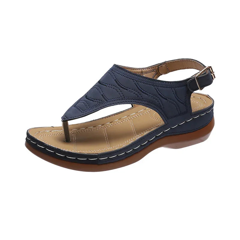 Navy blue leather women's sandal with cushioned tan insole and brown sole, adjustable ankle strap