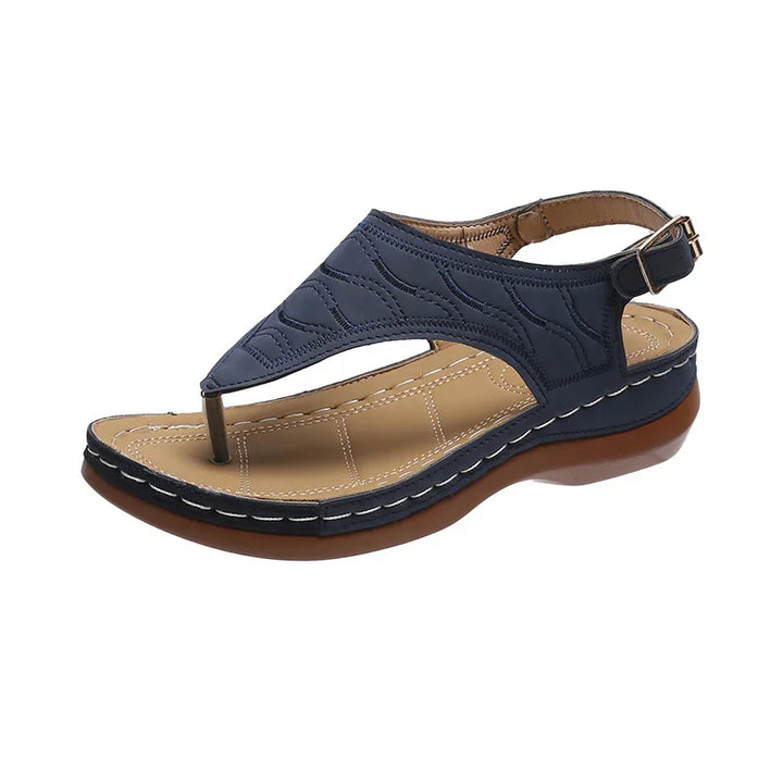 Navy blue leather women's sandal with cushioned tan insole and brown sole, adjustable ankle strap