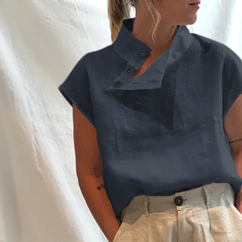 Woman wearing a navy blue sleeveless button-up linen top with beige high-waisted trousers