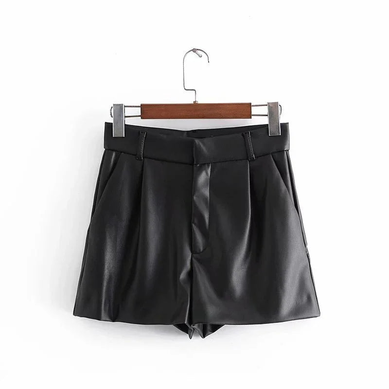 Black faux leather women’s high-waist shorts with belt loops on wooden hanger
