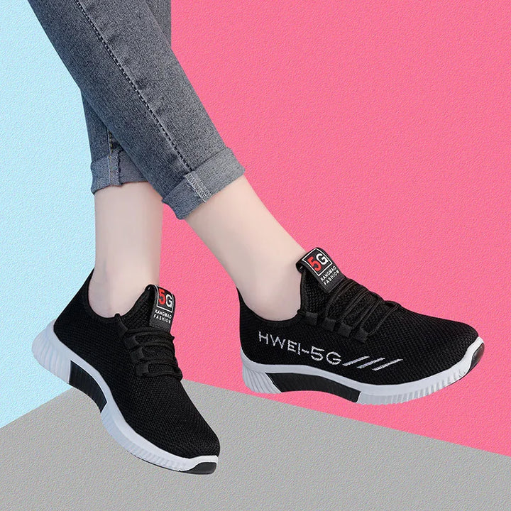 Black HWEI-5G knit sneakers with white soles on feet wearing rolled-up gray jeans