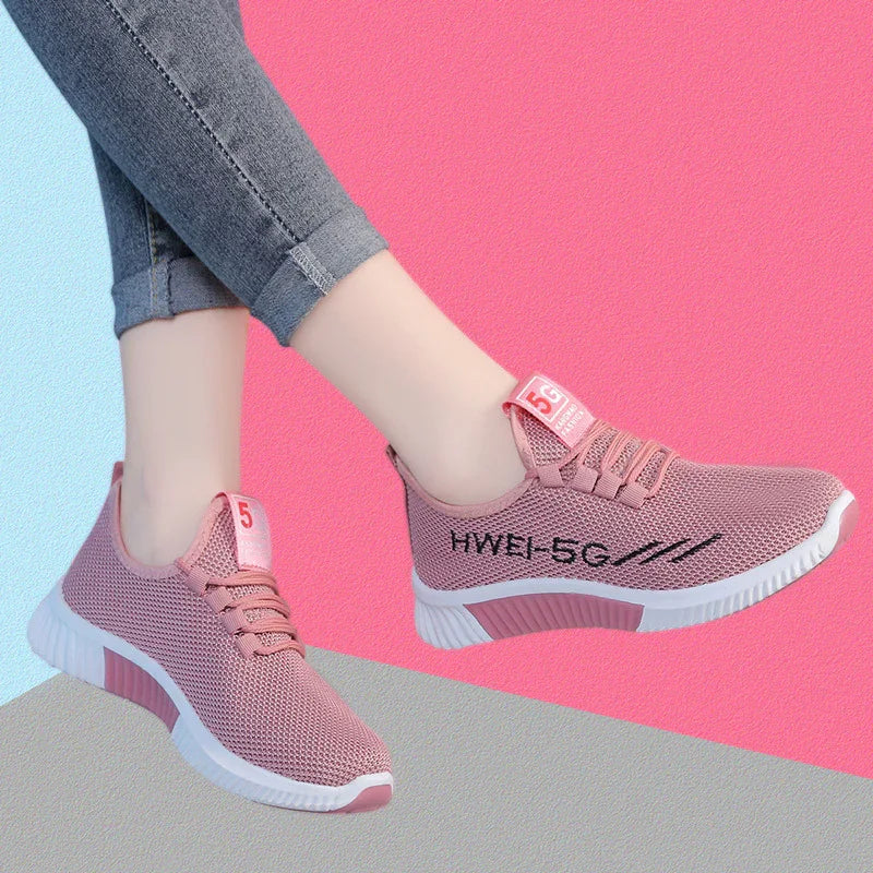 light pink breathable sneakers with white soles worn with grey rolled-up jeans on pink and blue background