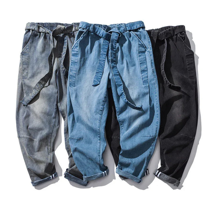 Three pairs of casual denim pants in grey, blue, and black with drawstring waist and rolled cuffs