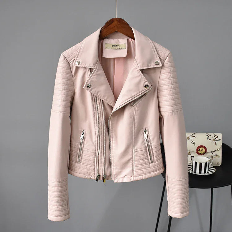 Light pink quilted leather jacket with silver zippers on wooden hanger against gray background