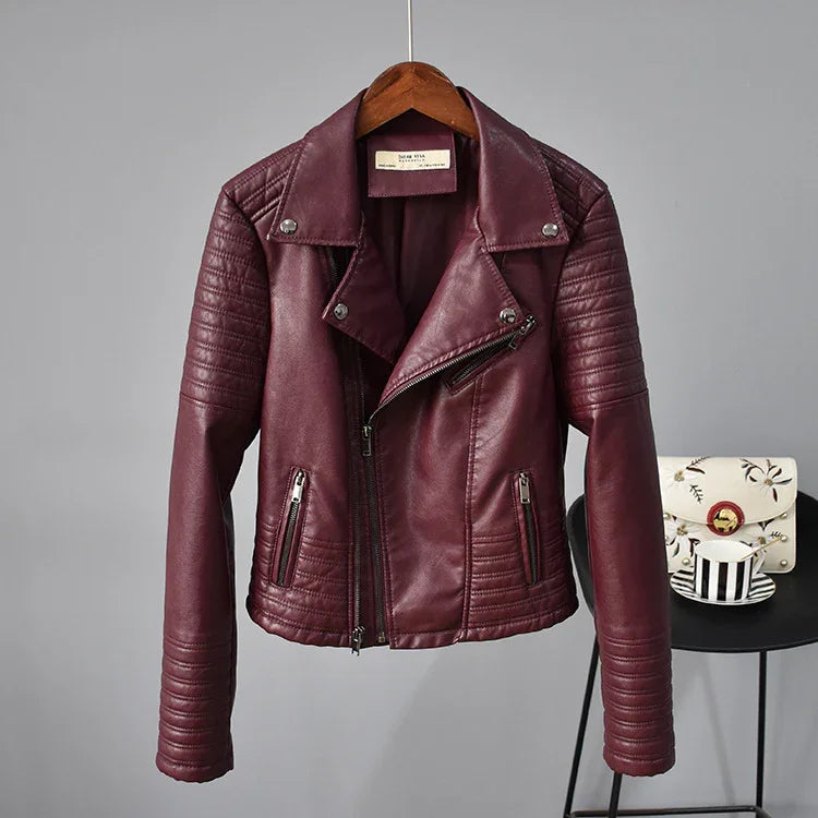 Maroon leather biker jacket with quilted stitching, silver zippers, hanging on wooden hanger