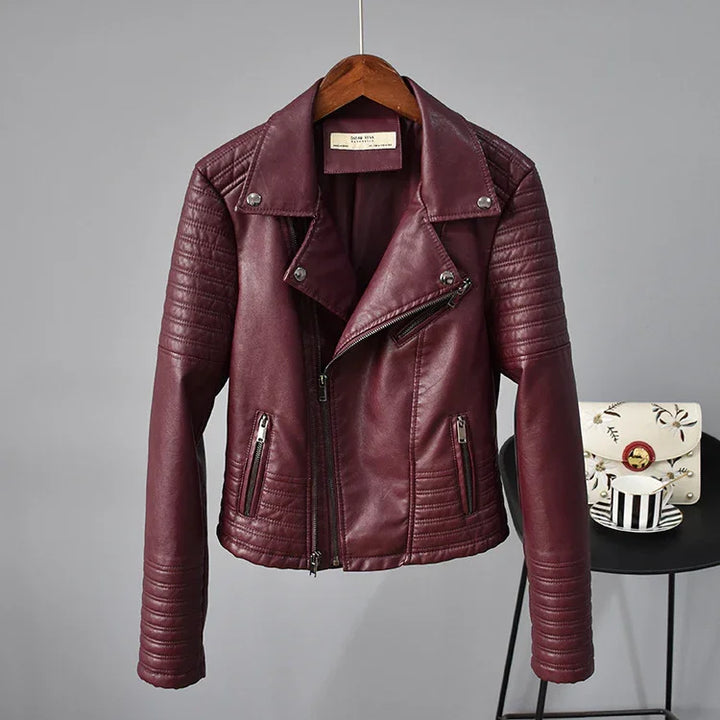 Maroon leather biker jacket with quilted stitching, silver zippers, hanging on wooden hanger