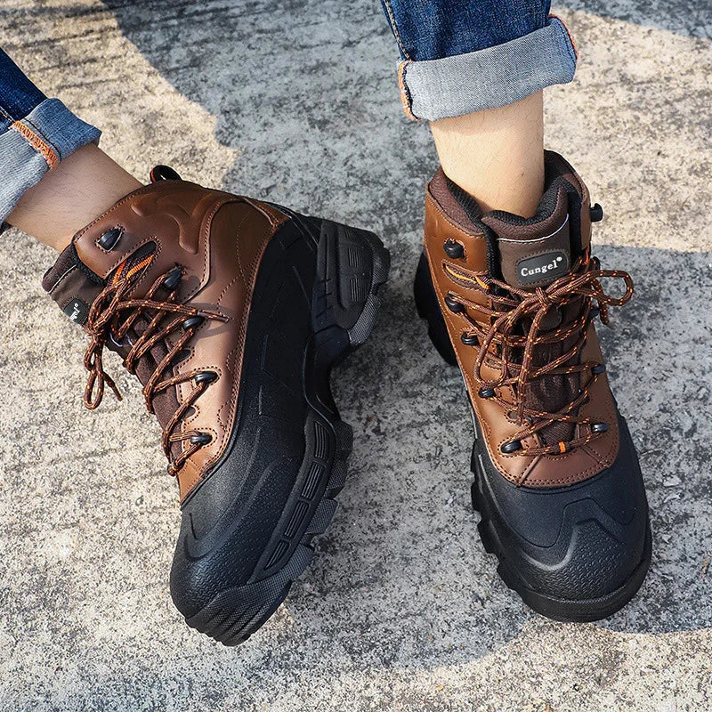 Brown and black Cungel hiking boots with laces worn with rolled-up jeans on concrete surface