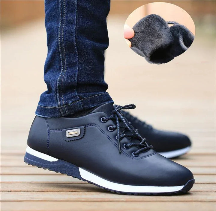 Men's black leather winter shoes with fleece lining and white sole, worn with blue jeans