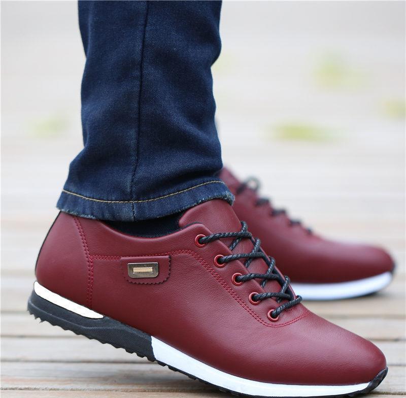Close-up of stylish maroon leather sneakers with black laces and white sole worn with dark blue jeans
