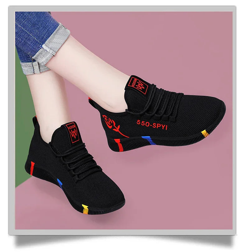 Black mesh sneakers with red rose graphic and colorful sole accents worn with rolled-up blue jeans
