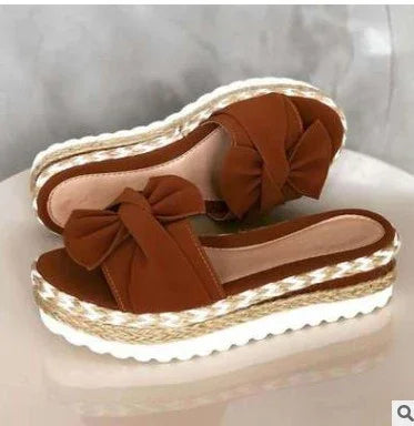 Brown platform espadrille sandals with large decorative bows and woven rope detailing