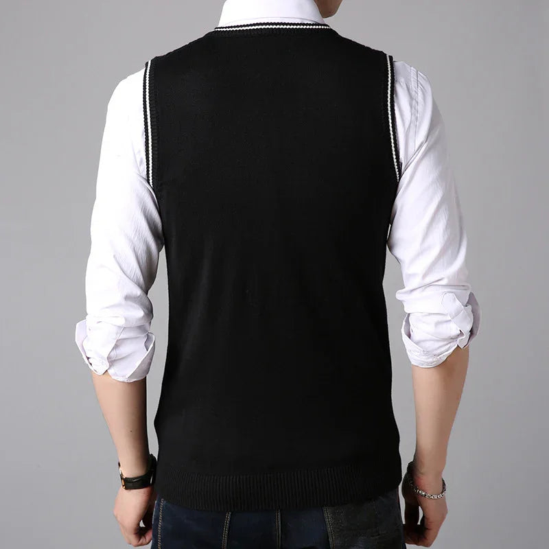 Back view of man wearing black sleeveless sweater vest over white rolled-up shirt