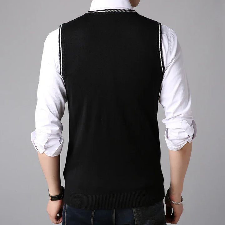 Back view of man wearing black sleeveless sweater vest over white rolled-up shirt