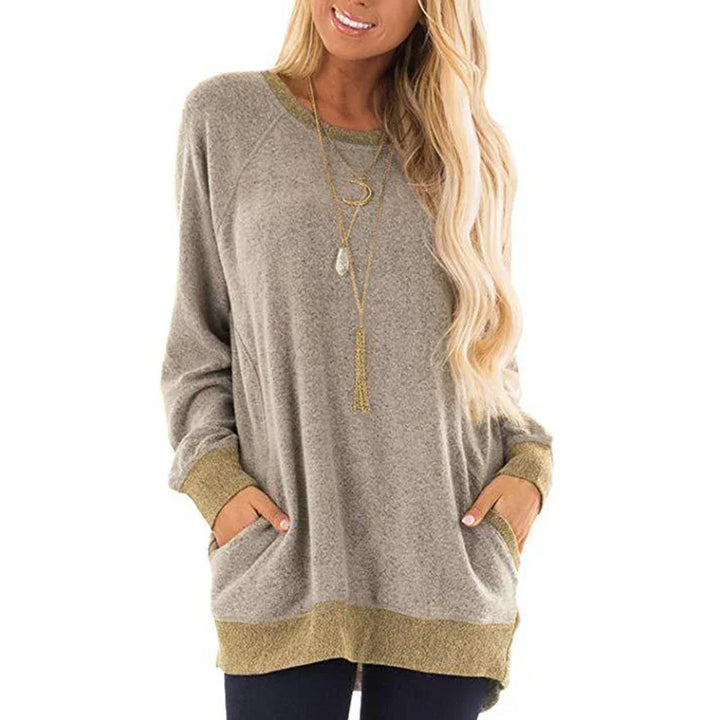 Women’s loose fit beige sweatshirt with gold trim cuffs and hem, long sleeves, and front pockets