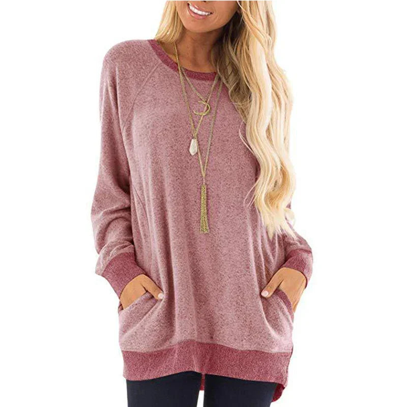 Woman wearing oversized mauve long sleeve sweater with pockets and layered gold necklaces