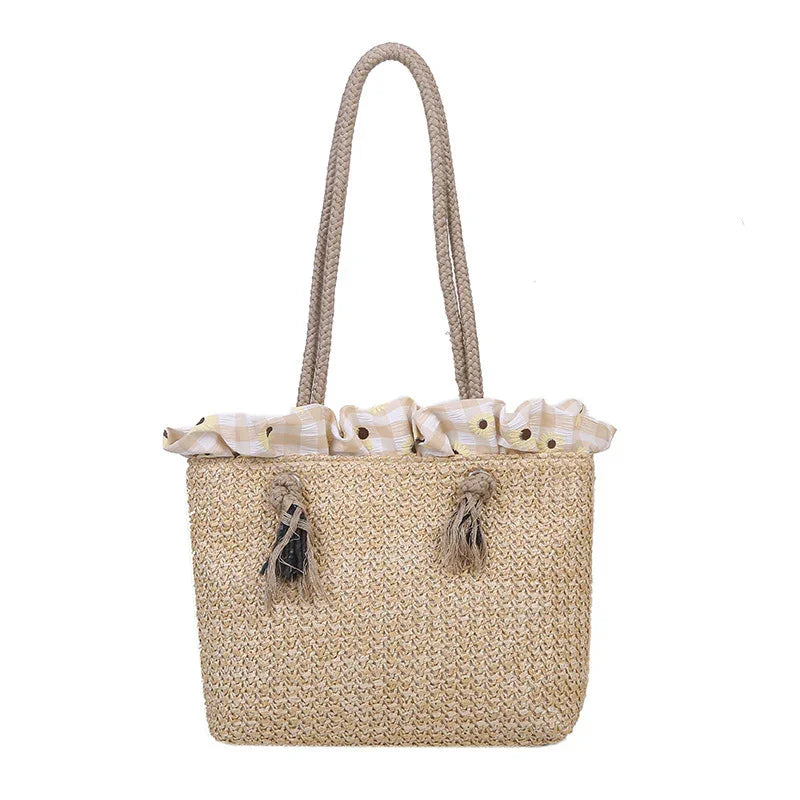 Woven straw tote bag with braided handles and fabric top featuring sunflower print