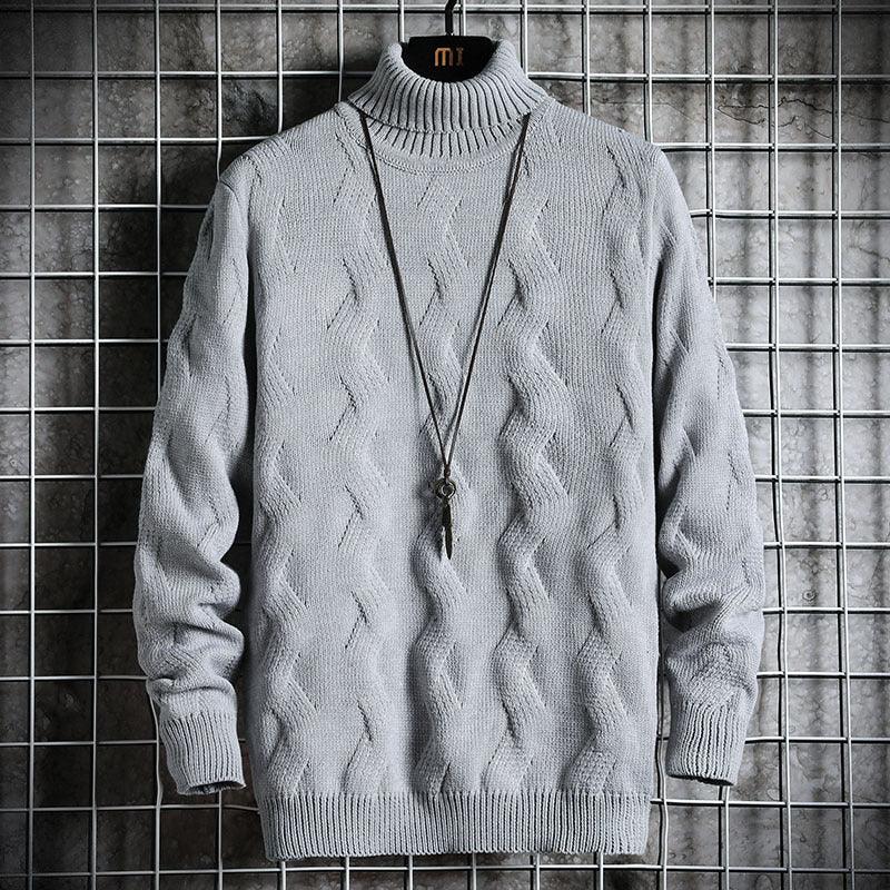 Gray knitted turtleneck sweater with cable patterns, hanging on grid background with pendant necklace