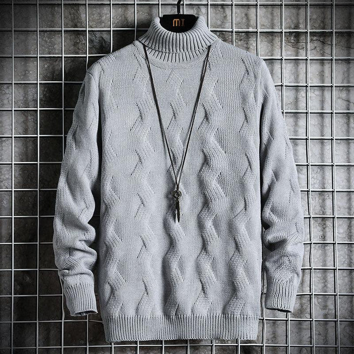 Gray knitted turtleneck sweater with cable patterns, hanging on grid background with pendant necklace