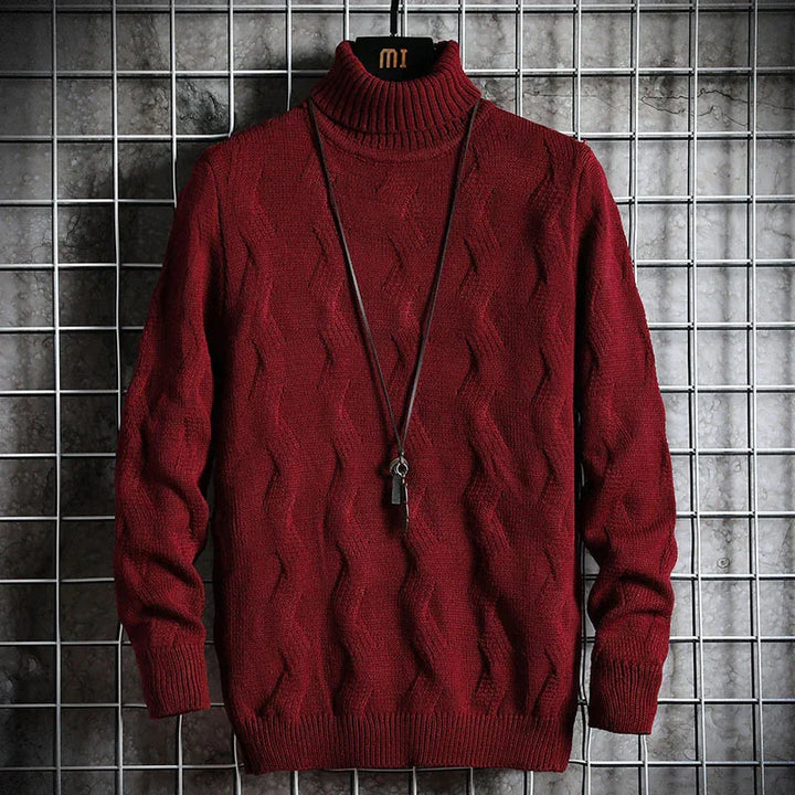 Maroon cable knit turtleneck sweater with pendant necklace on grid metal background