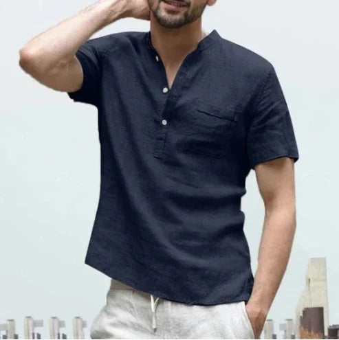 Man wearing a casual short-sleeve navy linen shirt with buttons and chest pocket, city background