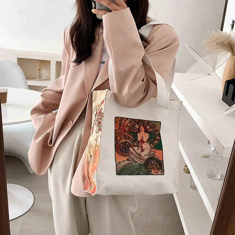 Woman in beige blazer holding white tote bag with vintage art print in modern minimal interior