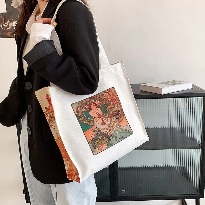Woman wearing black blazer carrying white canvas tote bag with vintage art print design