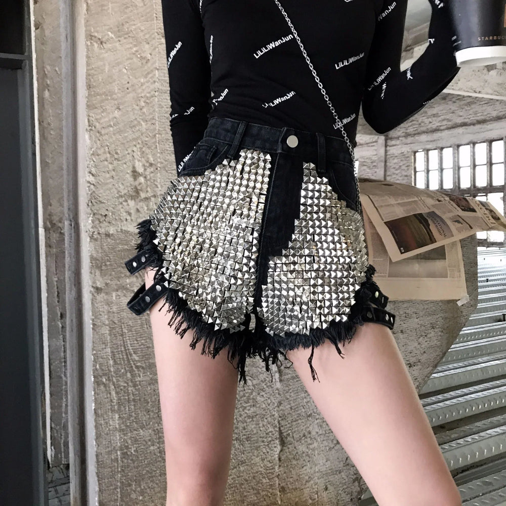 Fashionable black denim shorts with large silver stud embellishments and distressed edges