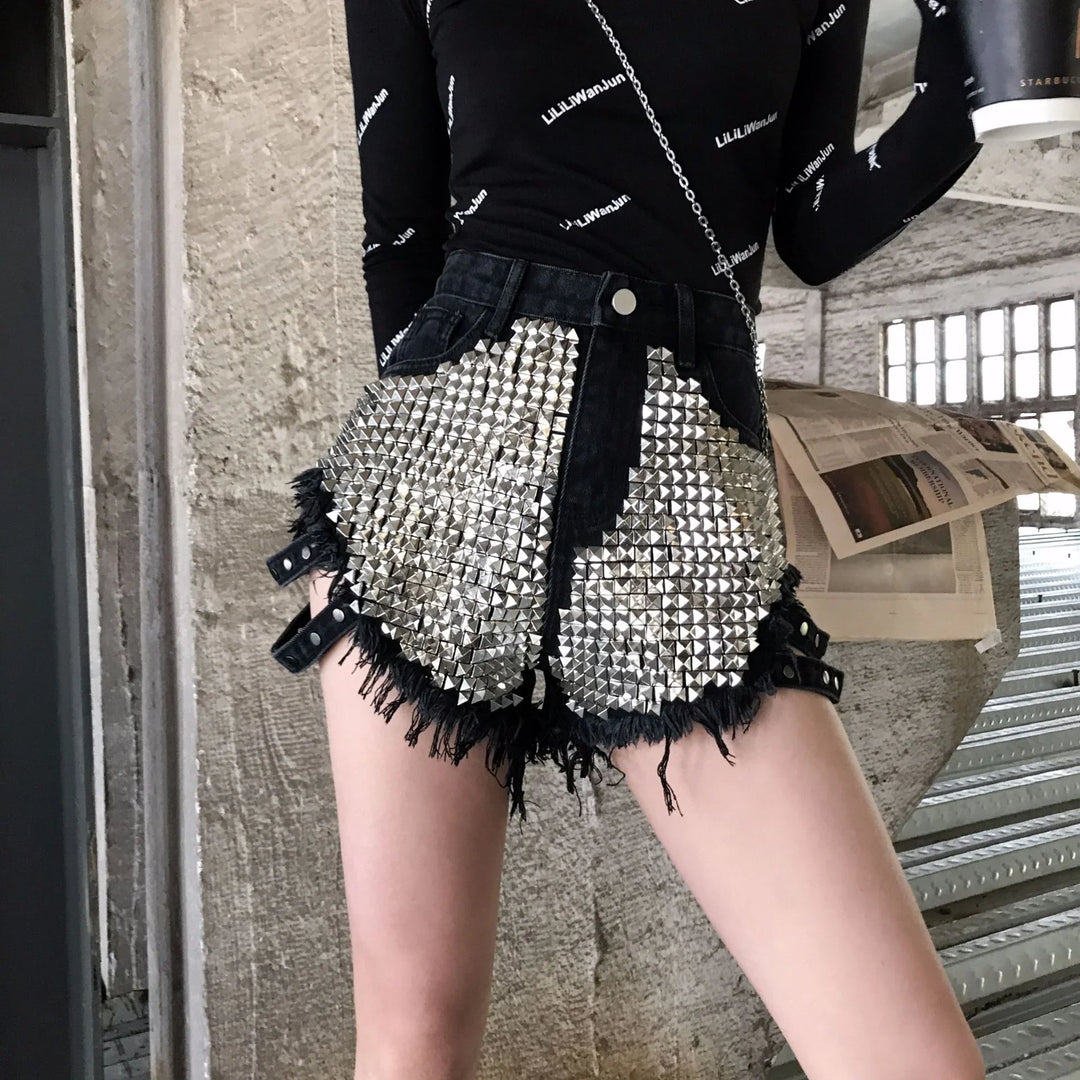 Fashionable black denim shorts with large silver stud embellishments and distressed edges