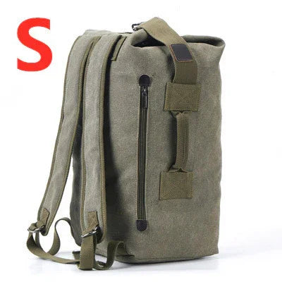 Small olive green canvas backpack with zipper pocket, adjustable straps, and top handle