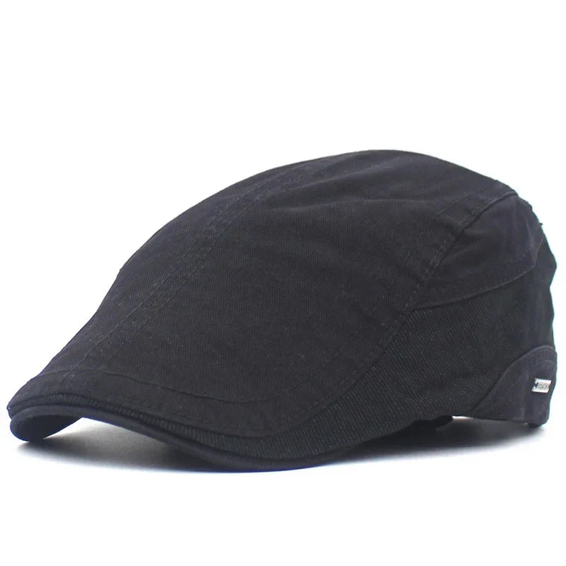 Black classic flat cap with stitched panels, made of soft fabric, isolated on white background