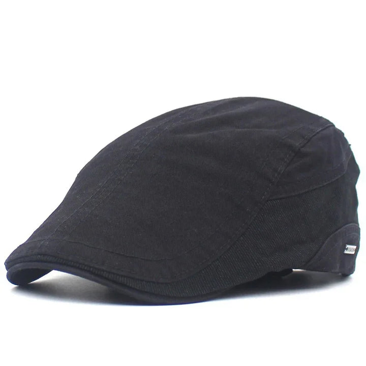 Black classic flat cap with stitched panels, made of soft fabric, isolated on white background